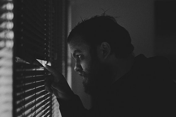 Man in the dark with blinds